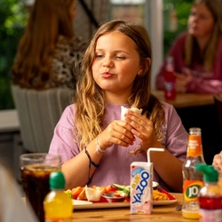An image of a young girl enjoying a wrap and drink within the interior restaurant and seating area at a Hungry Horse venue.