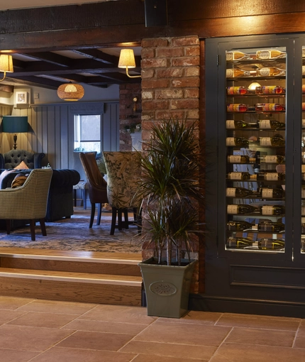 A wine fridge and seating area inside The Castle Hotel.