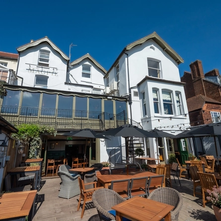A view of the rear exterior of The Magpie with outdoor beer garden seating area.