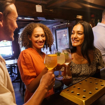An interior shot of people enjoying summer drinks at the bar at Urban Core & Heritage venues.