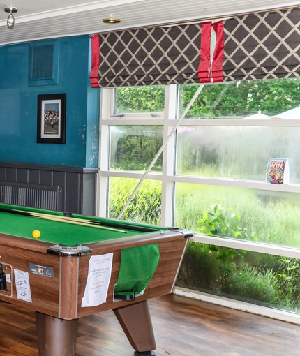 Interior area of a pub with a pool table.