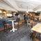 Interior dining area of a pub with a bar, a TV and a fireplace.