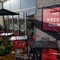 The exterior beer garden seating area at The Wrekin Giant in Telford, with a shade umbrella on one of the tables, and plants in wooden planter boxes.