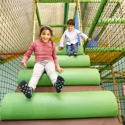 children in indoor play area sliding down steps