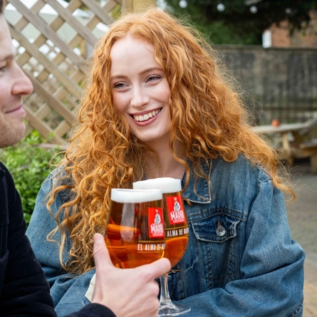 Two people enjoying a drink in a beer garden.