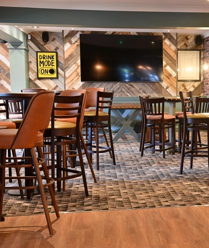 The interior restaurant seating area with TV and electronic pub game at The Greengage.