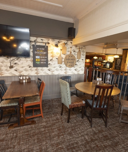 Interior dining area of a pub with a TV.