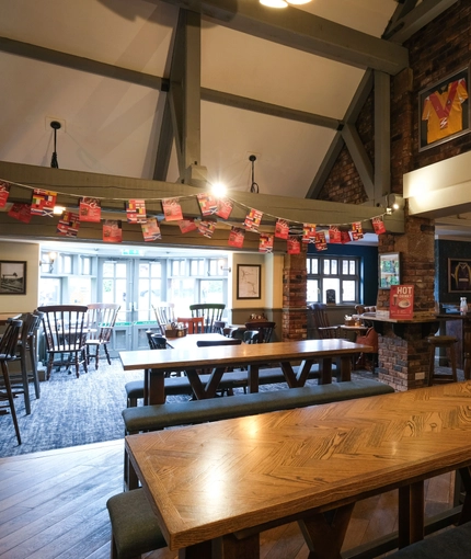 Interior dining area of a pub with a gambling machine.