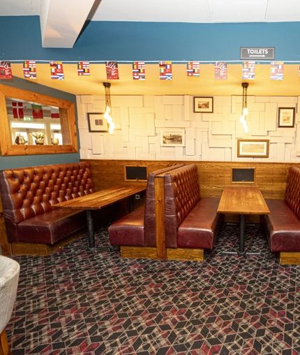 Interior dining area of a pub with TV screens.