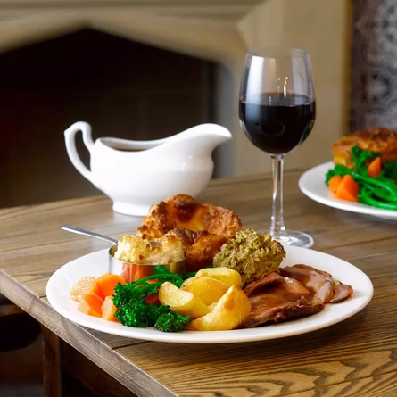 A roast dinner with a glass of red wine