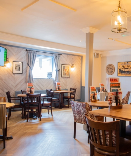 The interior restaurant and seating area with TV at the Poachers.
