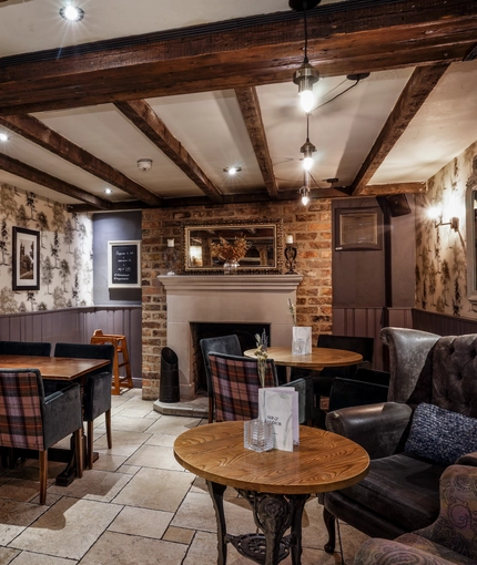 The restaurant and seating areas of The Old Mill, and a fireplace between the tables.