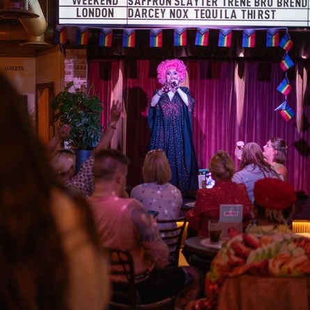 An interior image of one of the drag queen performers on the live event stage entertaining crowds during Pride Weekend at The City Of Quebec.