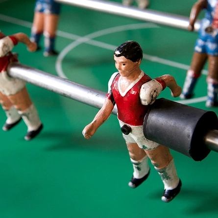 A close up view of the red and blue figures on a table football game.