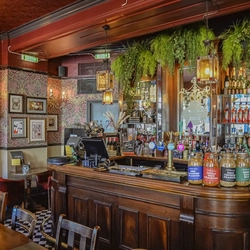 The bar and interior restaurant seating area with fireplace, at The Paxton's Head.