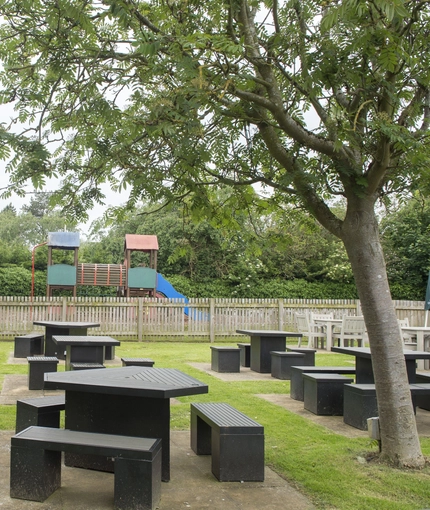 Exterior facade of a pub with a seating area with a play area.