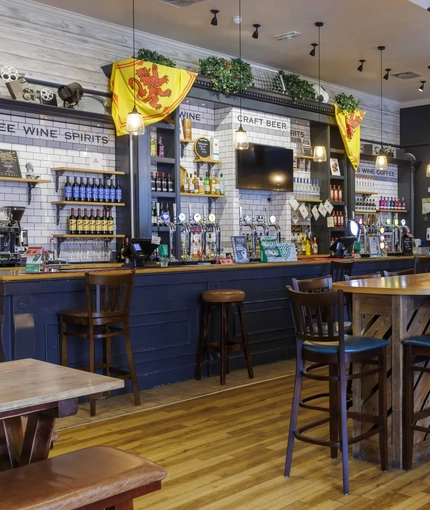 Interior dining area of a pub with TVs and a bar.