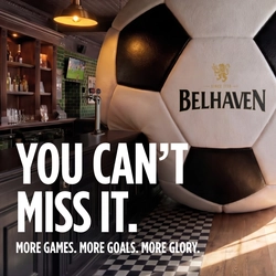A banner promoting the new football season at Belhaven venues. The banner shows an interior of a Belhaven-branded sports bar featuring a giant football-shaped wall installation beside the bar. Large white text reads “YOU CAN’T MISS IT.” with smaller text underneath stating “MORE GAMES. MORE GOALS. MORE GLORY.” A television screen showing a football match is visible in the background above beer taps and shelves of bottles.