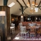 An interior restaurant seating area at The Green Man in Great Offley, with wooden flooring, upholstered booth seats, and windows in the high ceiling.