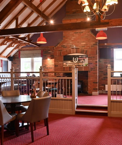 Interior dining area of a pub with a fireplace.