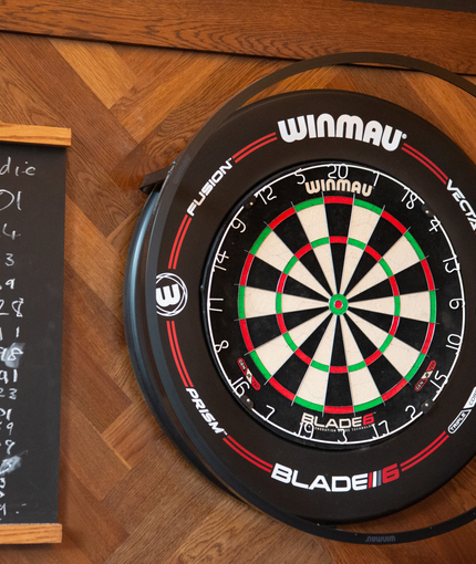A dartboard and scoreboard on the wall inside Coopers in Glasgow.