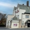 A view from across the street of the exterior facade, signage, beer garden seating area, and car park of The Railway.