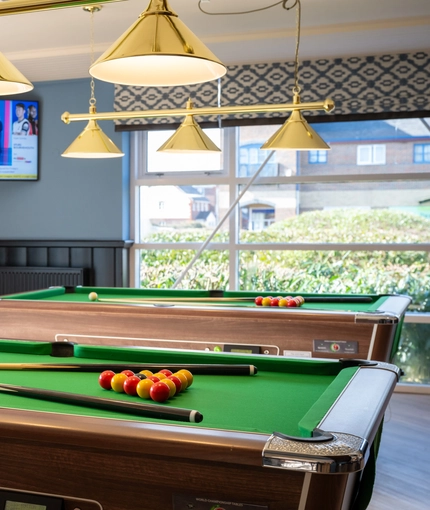 The interior games area with pool table and TV at The Woodlands.