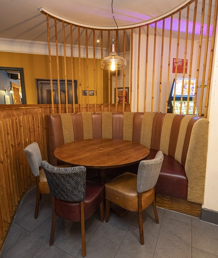 Interior dining area of a pub with a gambling machine.