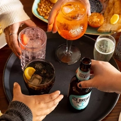 Hands grabbing drinks off of a serving tray.