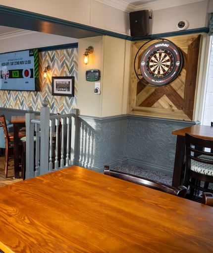 The interior restaurant and seating area with TV and games area with dart board at the Dragon.