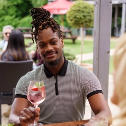 A mixed group of people sat in a beer garden, enjoying cocktails.