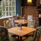 An interior restaurant seating area at The Fox & Hounds in Bursledon, with upholstered chairs and a brick fireplace.