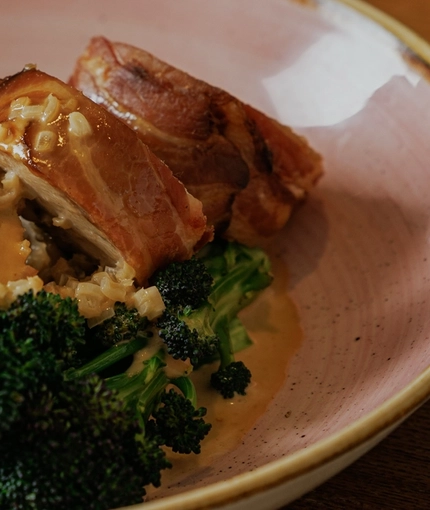 A lifestyle image of a bowled main dish from the Burns Night menu sat on a table within the interior restaurant seating area at The Crown.