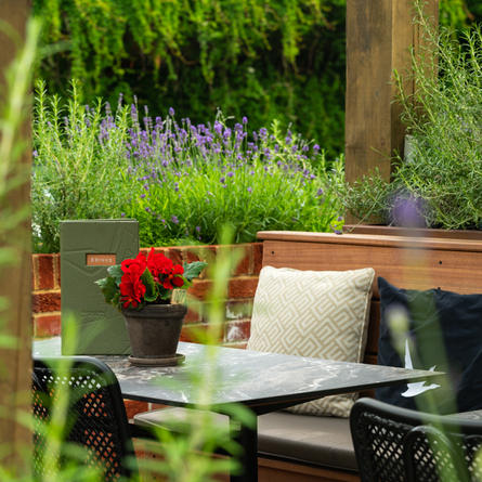 Exterior walled beer garden seating area under a wooden veranda at the rear of the Prince Of Wales.