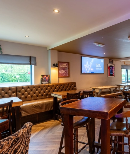 Interior dining area of a pub with a few TVs.