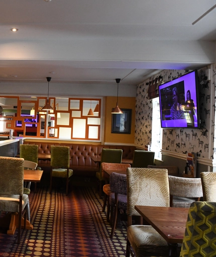 Interior dining area of a pub with a TV.