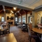 Interior dining area of a pub with a TV and a fireplace.