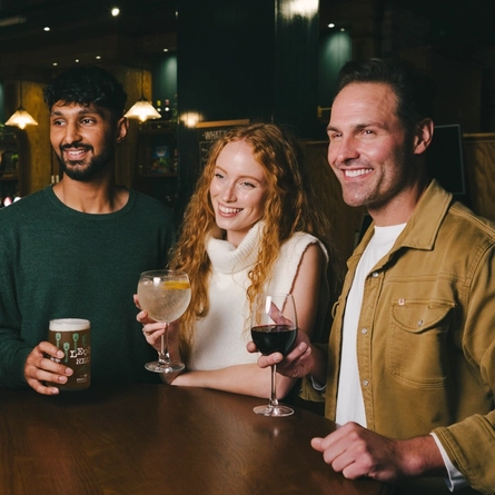 A lifestyle image of 4 friends stood enjoying various drinks within the interior of an Urban Core Venue.