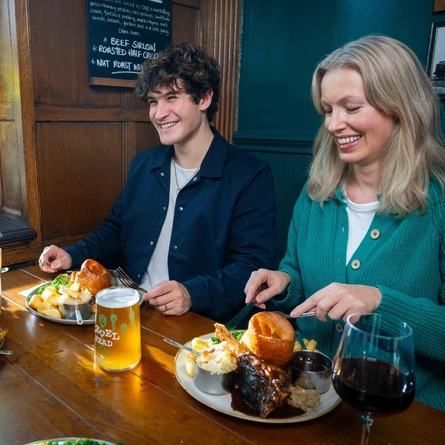 A group of friends seated in the restaurant and seating area of a Urban Social venue, enjoying Sunday roast dinners and drinks.