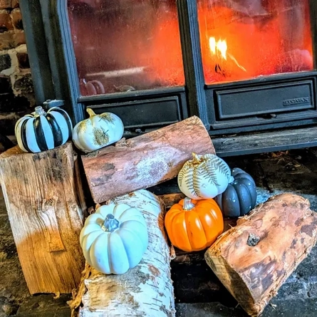 An image of pumpkins in front of a fire advertising a Halloween Pumpkin Trail What's On event at The Cart & Horses.