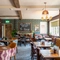 The interior restaurant seating area at The Walkford, with upholstered booth seating, leaded windows, and a fireplace.