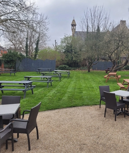 Outdoor Beer Garden with tables and benches on grass and gravel