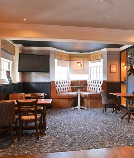 Interior dining area of a pub with a TV.