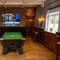 The interior games area at The Hussey Arms in Brownhills, with a pool table, a TV on the wall, and bar stool seating.