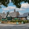 The exterior facade of the venue, car park, venue signage and wooden bench outdoor seating area at The Church View Inn.