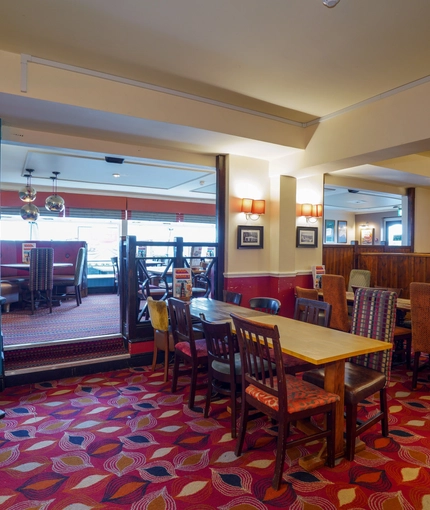 Interior dining area of a pub with a gambling machine.