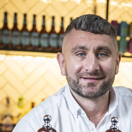 A man standing behind a bar.