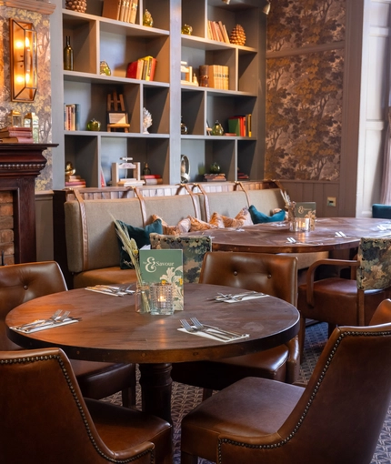 Some tables near a fireplace in the restaurant of Himley House.