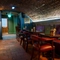 The interior restaurant seating area with tables, chairs, cushioned seating, arched brick ceiling and tiled flooring at The Watergates Bar.