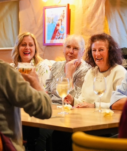 Guests sitting at a table inside The Pack Horse in Burnopfield, with glasses of wine on the table in front of them.